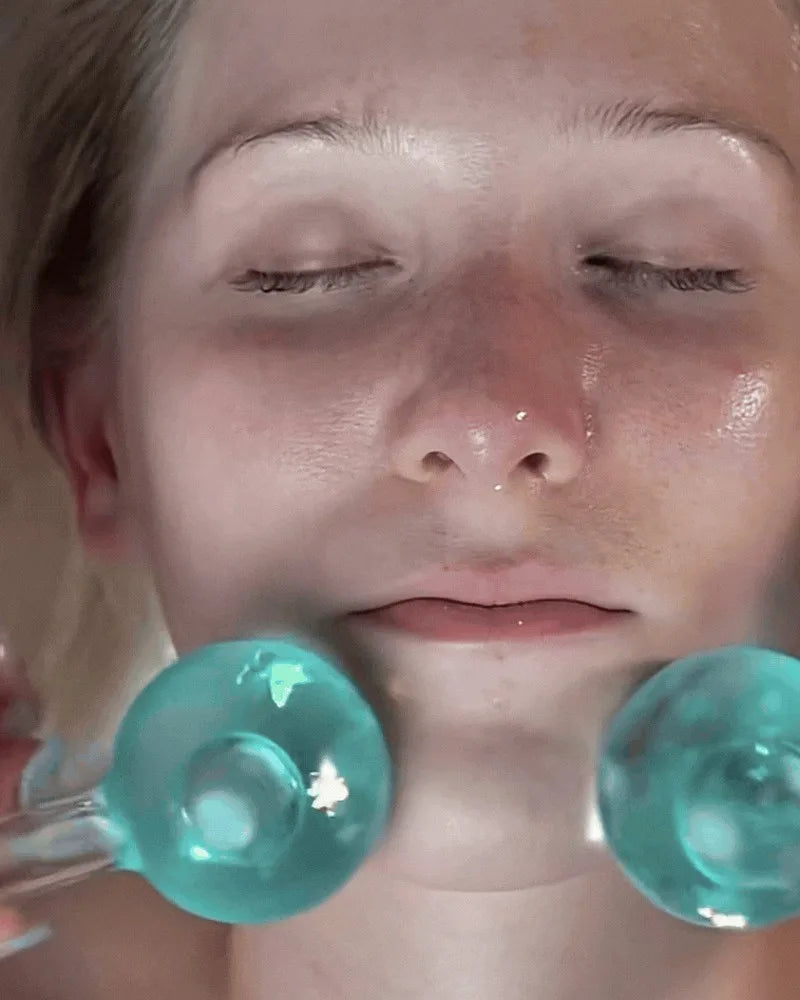 Chilled facial globes gliding over a resting guest's cheeks during a Korean Oxygen Facial